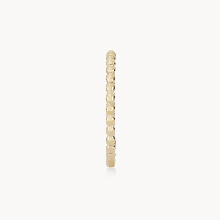 A thin gold bracelet composed of multiple small, polished, spherical beads connected in a single row, creating a simple yet elegant piece of jewelry. It is displayed against a white background is the abacus ring - 10k yellow gold by bluboho.