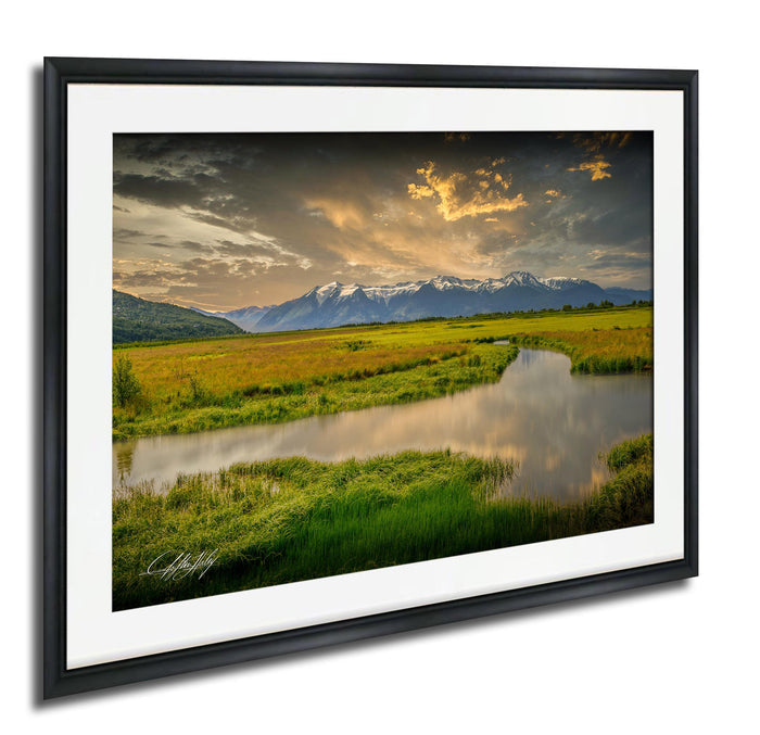 a serene landscape with a river, mountains, and a cloudy sky.