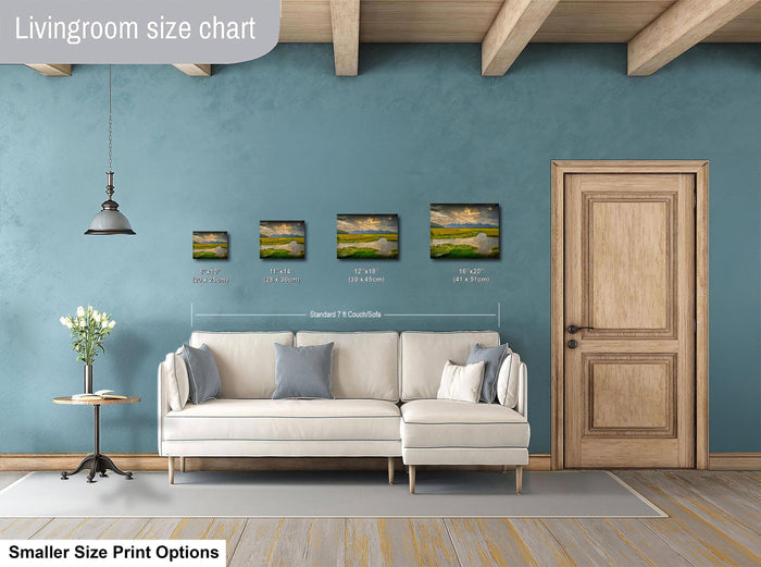 a living room with a white sofa, a wooden door, and a hanging light fixture. There are three framed landscape paintings displayed on the wall, each with a different size.