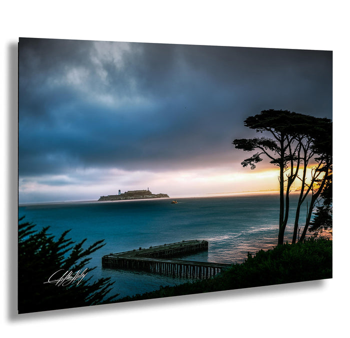 a serene coastal scene with a pier extending into the ocean, a small island in the distance, and a dramatic sky with clouds and a colorful sunset.