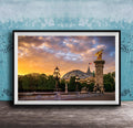 a picturesque scene of a cityscape with a large domed building, ornate lampposts, and a statue of a winged figure, all set against a vibrant sunset sky.
