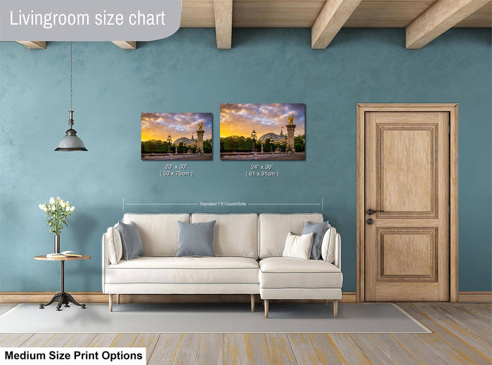 a living room with a white sofa, a wooden door, and a painting of a sunset on the wall. The painting is of a building with a tower. The living room appears to be well-lit and decorated with a vase of flowers on a table.