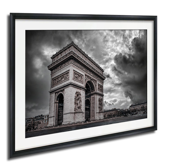 The image is a black and white photograph of the Arc de Triomphe in Paris, France, with dramatic clouds in the background.