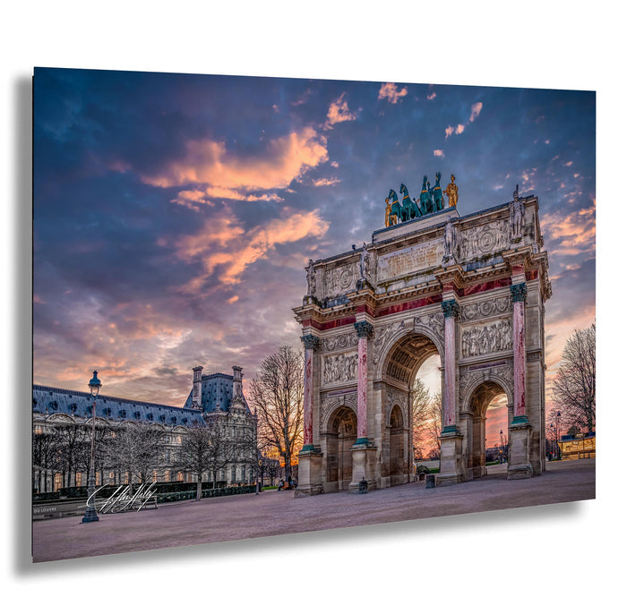 a large, ornate archway with intricate carvings and statues, set against a vibrant sky with colorful clouds. The archway is surrounded by trees and other buildings, creating a picturesque scene.