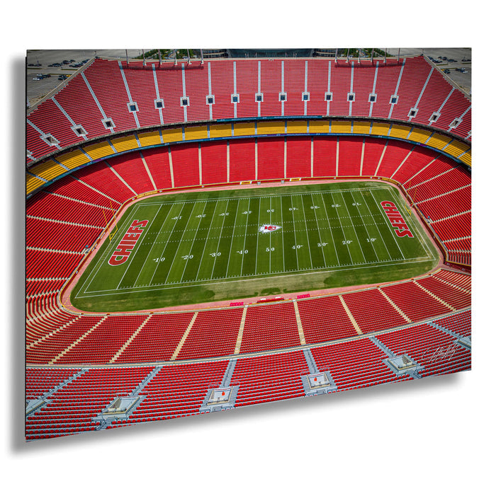 an aerial view of a football stadium with a large field and rows of red seats.