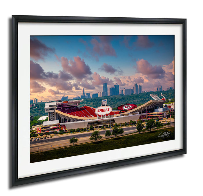 A framed photograph of the Kansas City Chiefs football stadium, with the city skyline in the background.