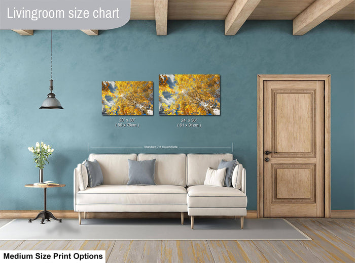 a living room with a white sofa, a wooden door, and a painting of a tree with yellow leaves hanging on the wall.