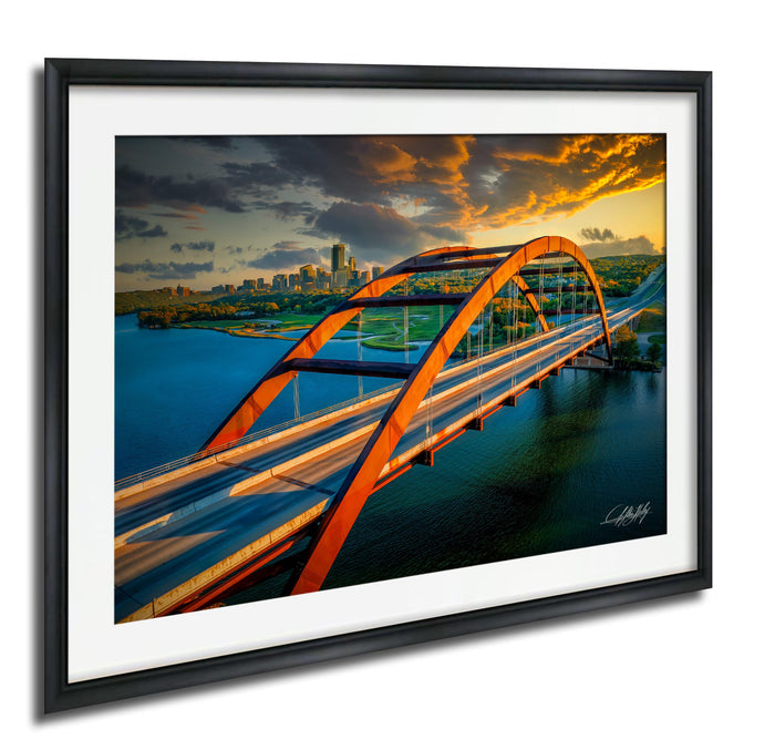 a large, orange bridge spanning across a body of water, with a city skyline visible in the background.