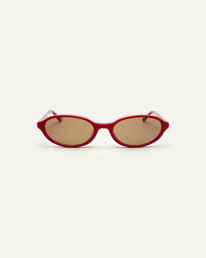 Face shot of Bonnie Clyde Baby oval sunglasses in layered red with brown lenses.