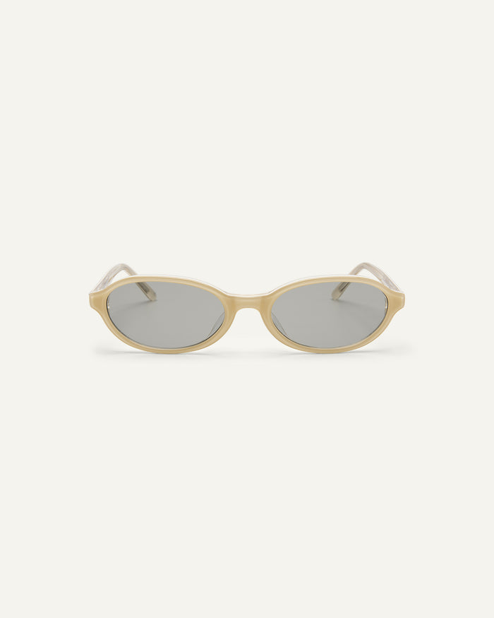 Face shot of Bonnie Clyde Baby oval sunglasses in layered off white with grey lenses.