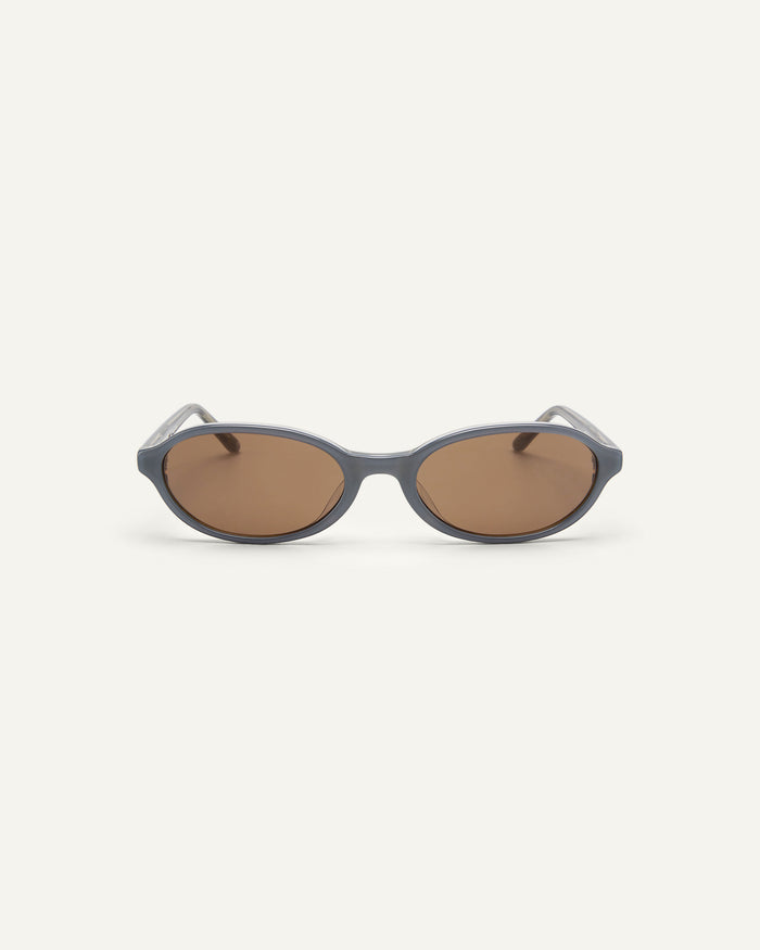 Face shot of Bonnie Clyde Baby oval sunglasses in layered silver with brown lenses.