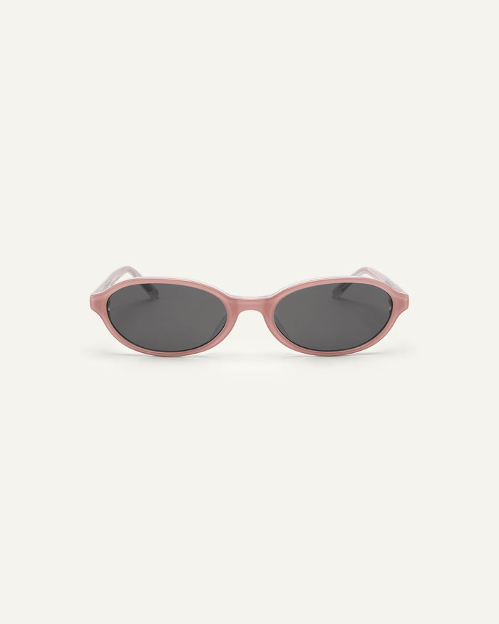 Face shot of Bonnie Clyde Baby oval sunglasses in layered pink with black lenses.