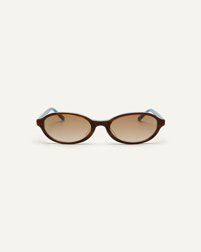 Face shot of Bonnie Clyde Baby oval sunglasses in layered teal demi with brown gradient lenses.