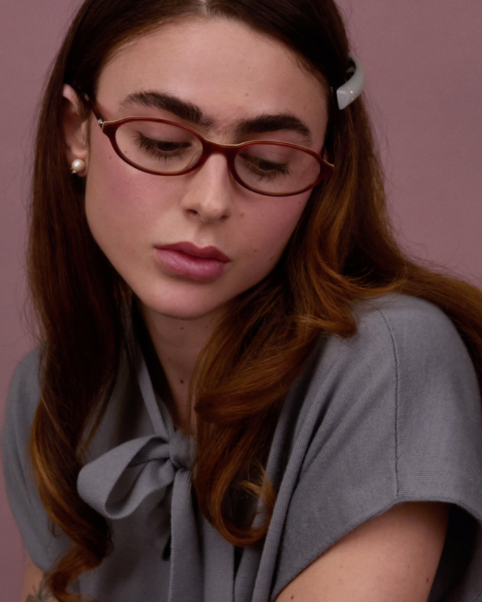 Quarter shot of Bonnie Clyde Baby oval optical frames in layered brown with clear lenses.