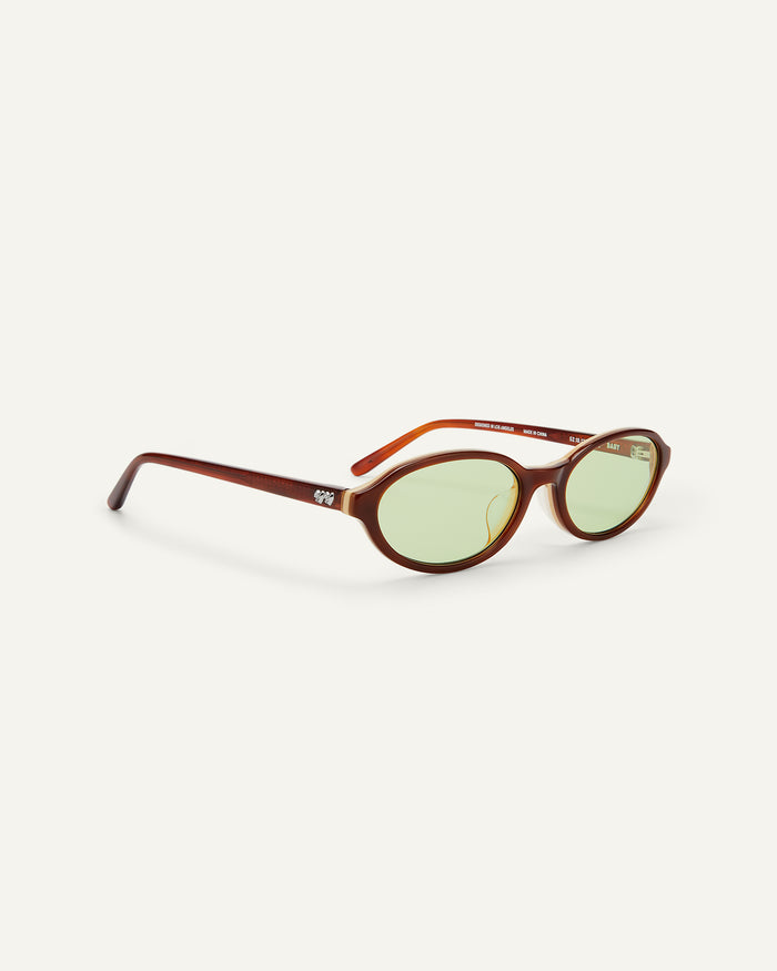Side shot of Bonnie Clyde Baby oval sunglasses in layered brown with green lenses.