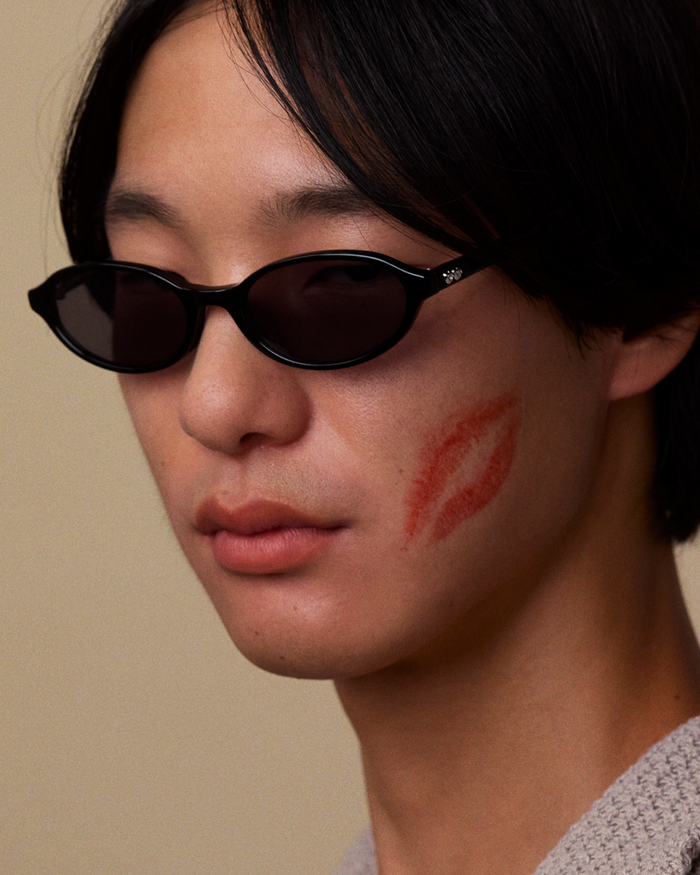 Side shot of Bonnie Clyde Baby oval sunglasses in black with black lenses.