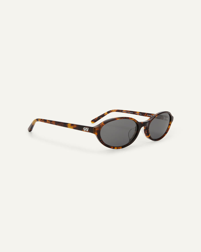 Side shot of Bonnie Clyde Baby oval sunglasses in tortoise with black lenses.