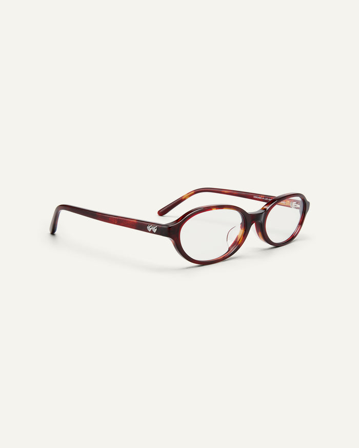 Side shot of Bonnie Clyde Baby oval optical frames in red tortoise with clear lenses.