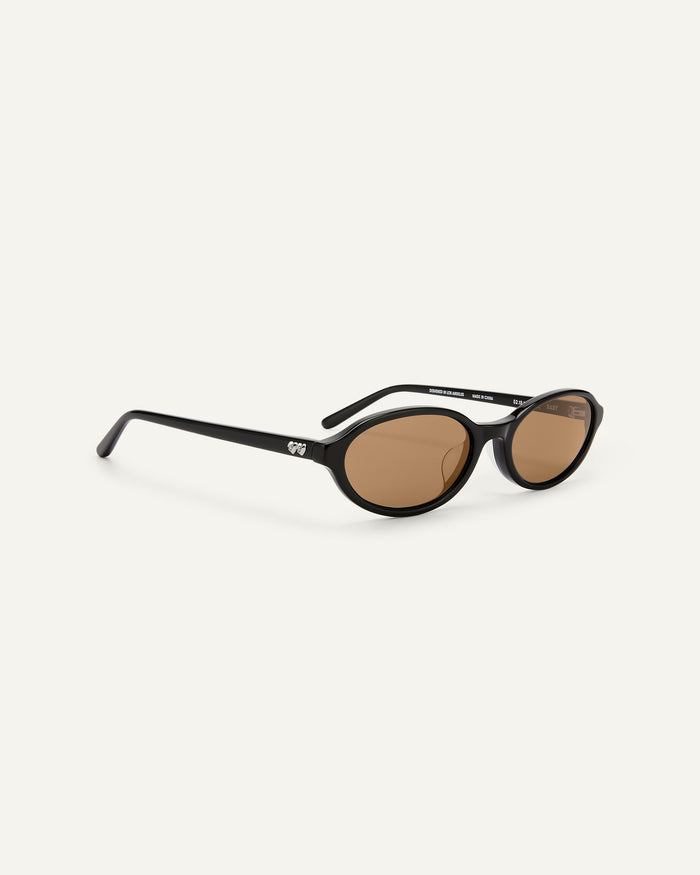 Side shot of Bonnie Clyde Baby oval sunglasses in black with brown lenses.