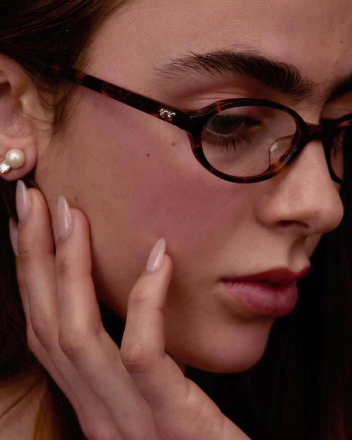 Close-up shot of Bonnie Clyde Baby oval optical frames in tortoise with clear lenses.