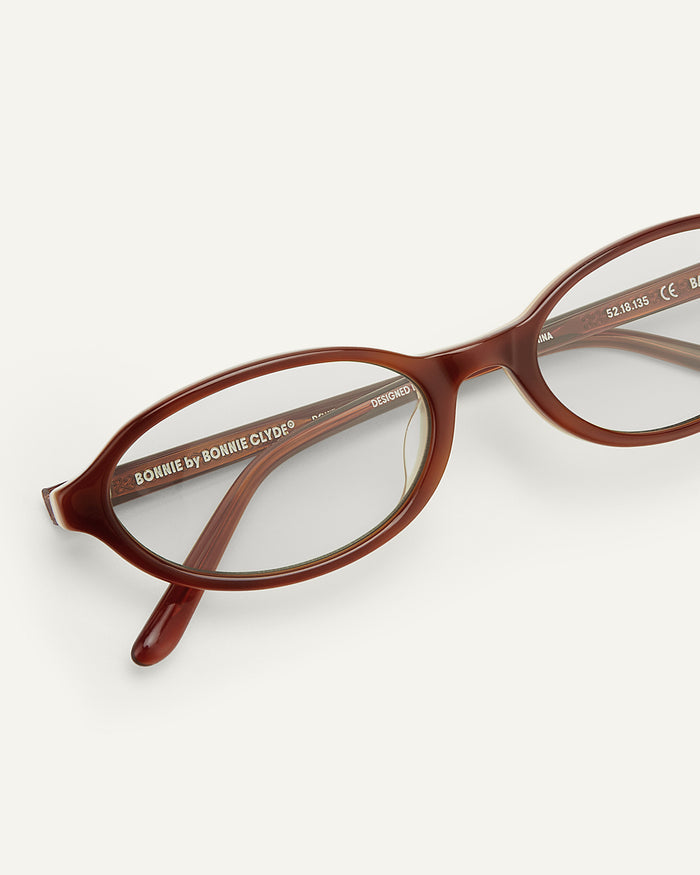 Close-up shot of Bonnie Clyde Baby oval optical frames in layered brown with clear lenses.