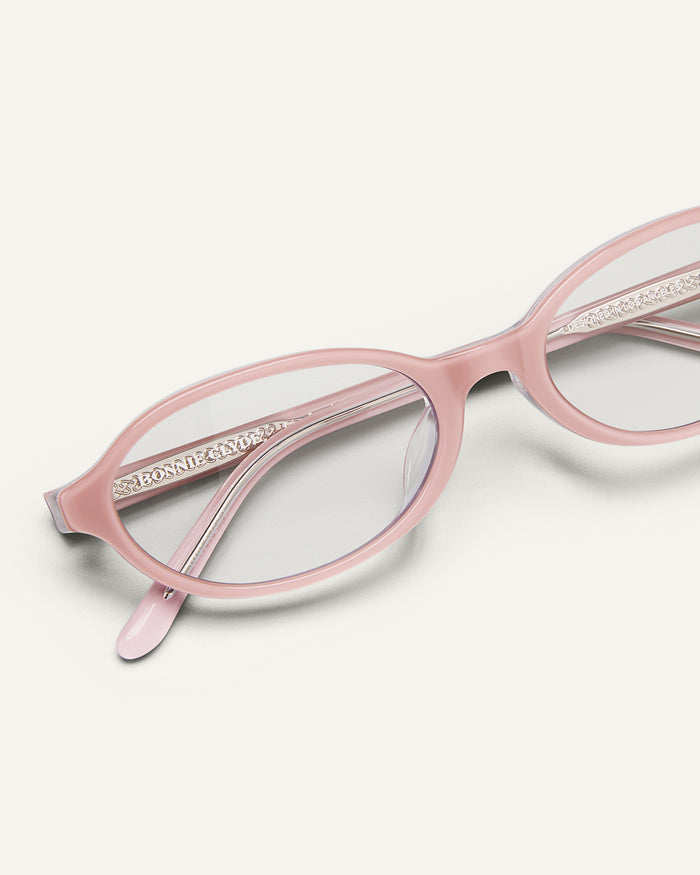 Close-up shot of Bonnie Clyde Baby oval optical frames in layered pink with clear lenses.