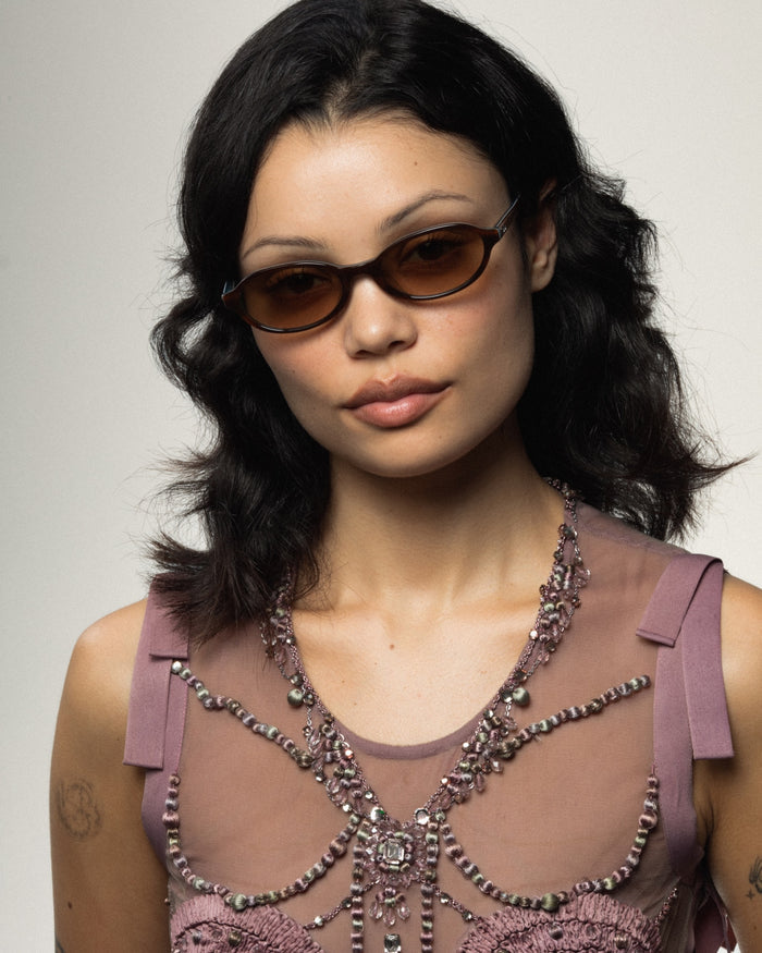Close-up shot of Bonnie Clyde Baby oval sunglasses in layered teal demi with brown gradient lenses.
