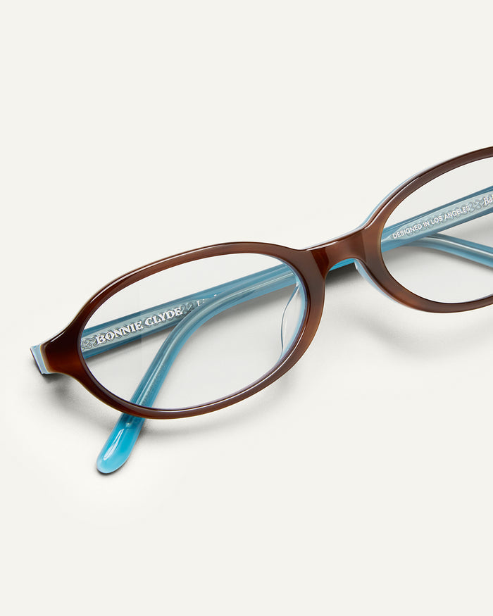 Close-up shot of Bonnie Clyde Baby oval optical frames in teal demi with clear lenses.
