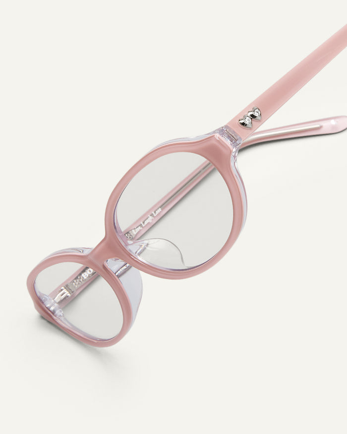 Detail shot of Bonnie Clyde Baby oval optical frames in layered pink with clear lenses.