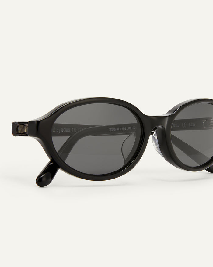 Detail shot of Bonnie Clyde Baby oval sunglasses in black with black lenses.