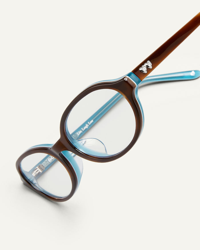 Detail shot of Bonnie Clyde Baby oval optical frames in teal demi with clear lenses.