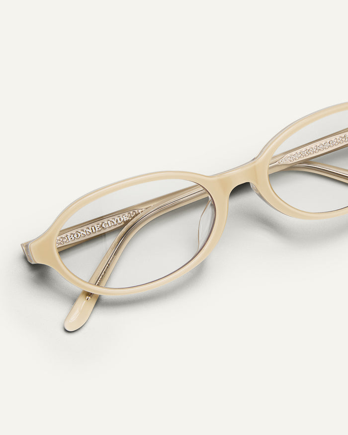 Detail shot of Bonnie Clyde Baby oval optical frames in layered off white with clear lenses.
