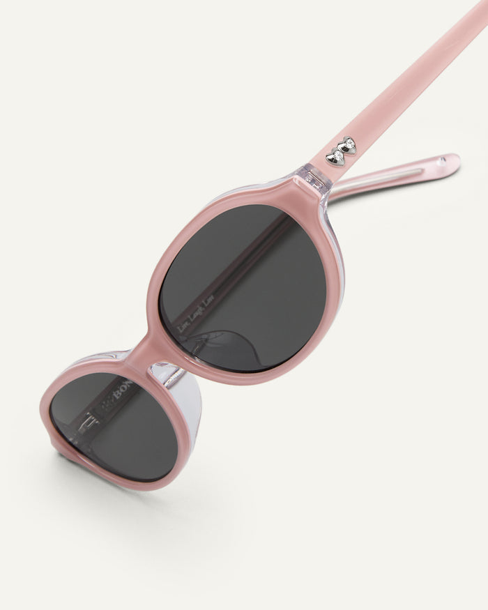 Additional view of Bonnie Clyde Baby oval sunglasses in layered pink with black lenses.