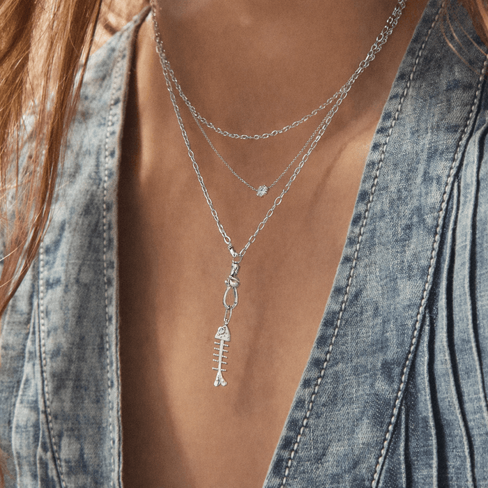 Close up on woman wearing bare bones fish necklace charm sterling silver