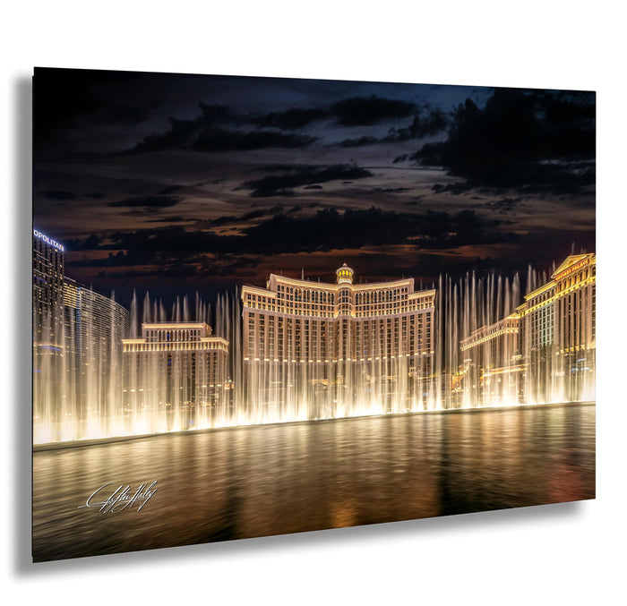 a large, illuminated building with a fountain in front of it, creating a visually striking scene at night.