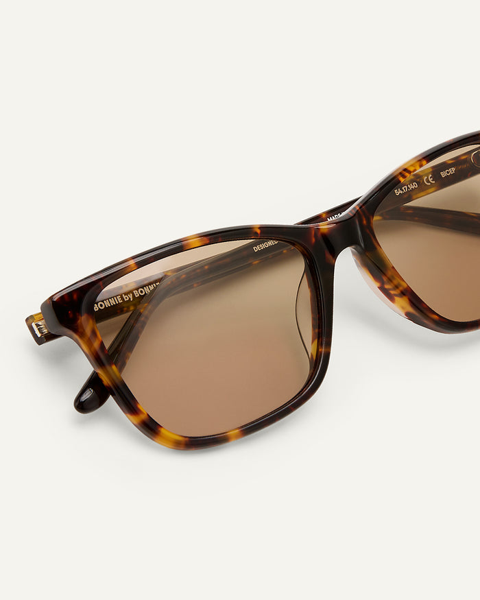 Side shot of Bonnie Clyde Bicep sunglasses in tortoise with brown lenses.