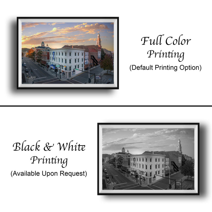 The image is a collage of two framed pictures. The left frame shows a city street with buildings and a clock tower, while the right frame is a black and white photograph of the same city street. The text below the images indicates that the full color printing is available upon request, and the black and white version is also available.