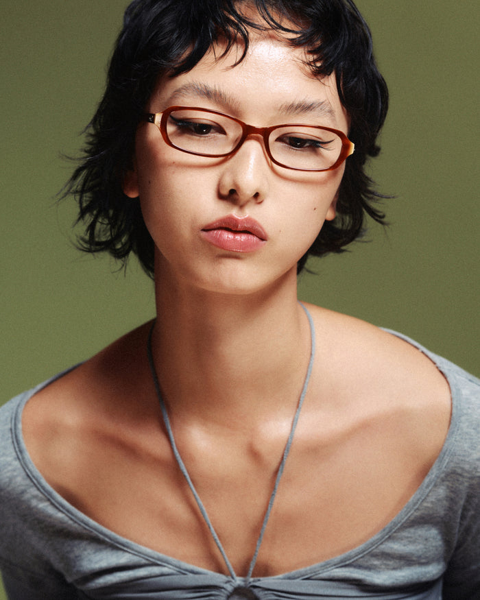 Quarter shot of Bonnie Clyde Blondie optical frames in layered brown with clear lenses.