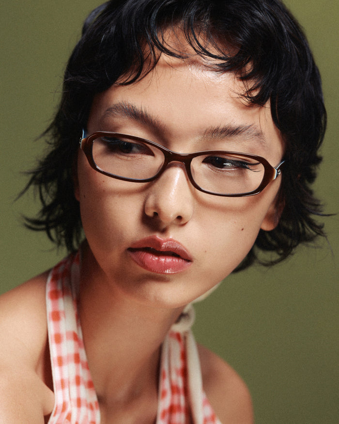 Quarter shot of Bonnie Clyde Blondie optical frames in layered teal demi with clear lenses.