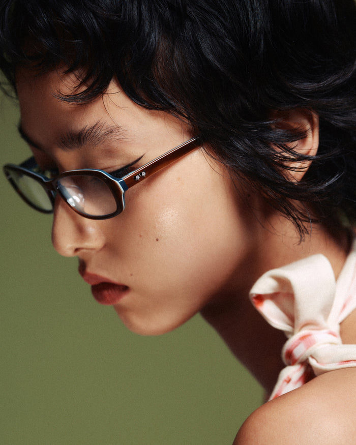 Side shot of Bonnie Clyde Blondie optical frames in layered teal demi with clear lenses.