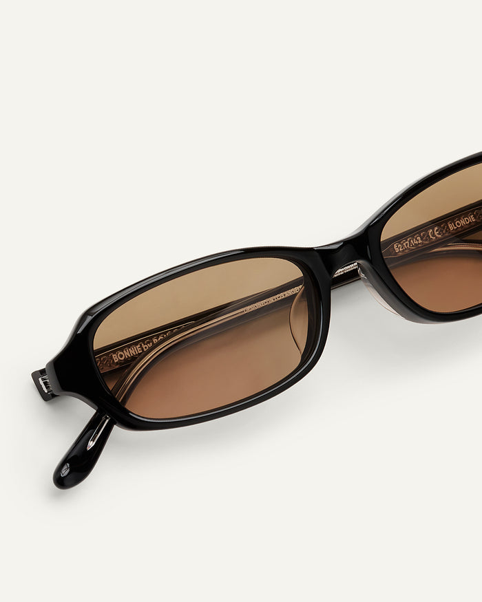 Close-up shot of Bonnie Clyde Blondie sunglasses in black with brown lenses.
