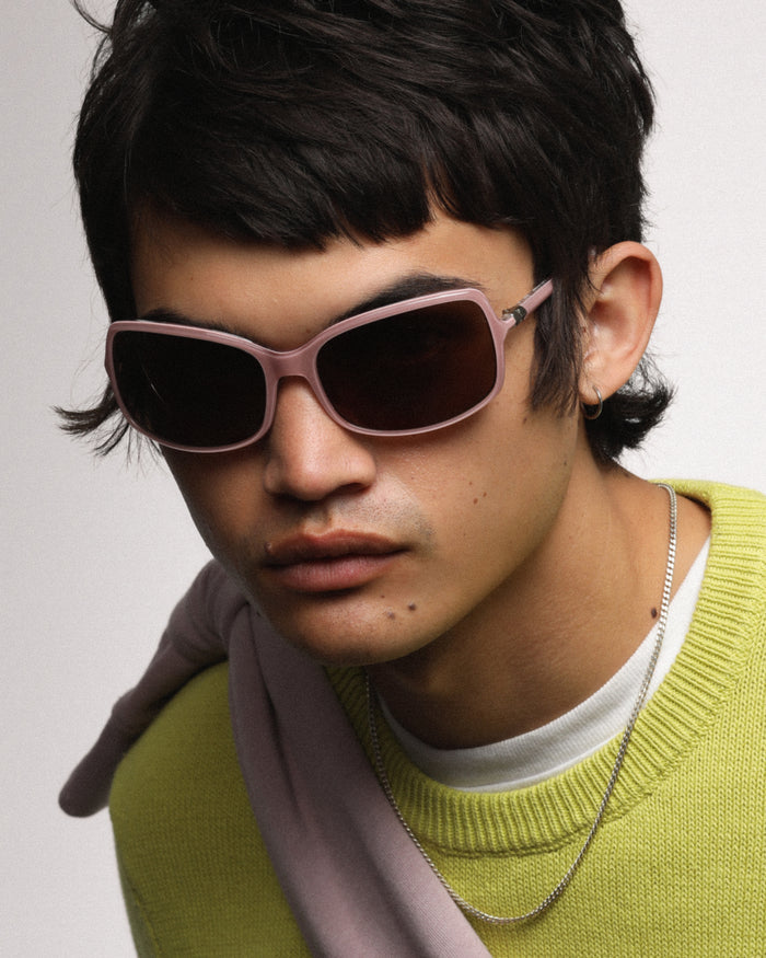 Quarter shot of Bonnie Clyde Body rounded square sunglasses in layered pink with brown lenses.