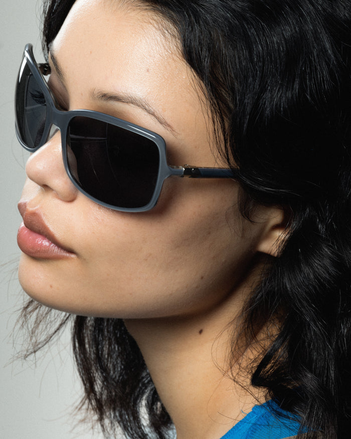 Quarter shot of Bonnie Clyde Body rounded square sunglasses in layered silver with black lenses.