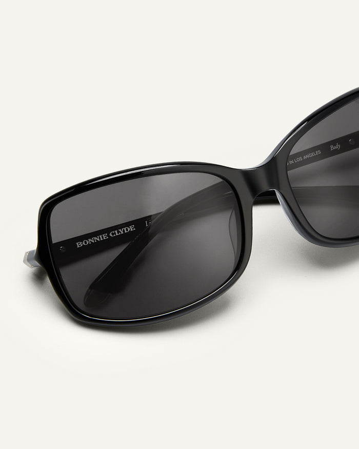 Side shot of Bonnie Clyde Body rounded square sunglasses in black with black lenses.