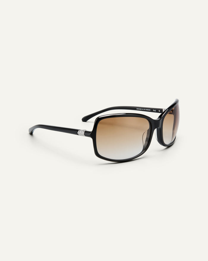 Quarter shot of Bonnie Clyde Body rounded square sunglasses in black with brown gradient lenses.