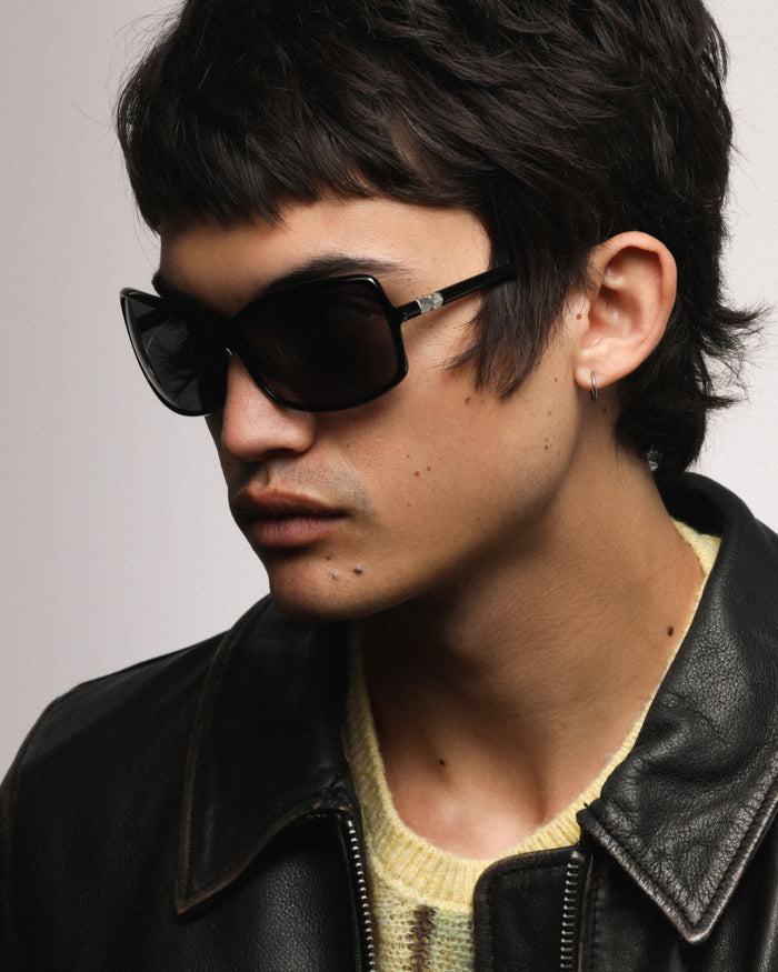 Detail shot of Bonnie Clyde Body rounded square sunglasses in black with black lenses.