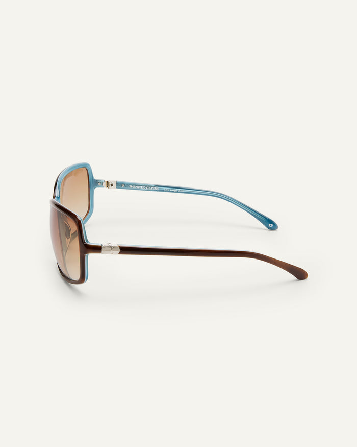 Detail shot of Bonnie Clyde Body rounded square sunglasses in teal demi with brown lenses.