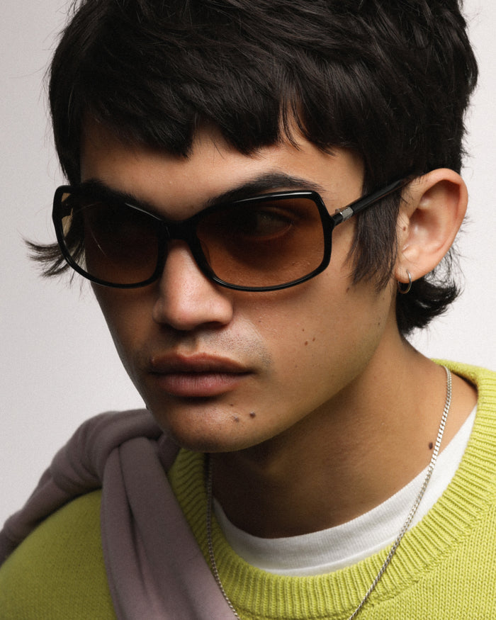 Close-up shot of Bonnie Clyde Body rounded square sunglasses in black with brown gradient lenses.