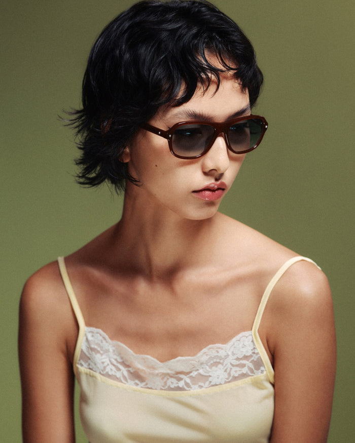 Quarter shot of Bonnie Clyde Boss Fight sunglasses in brown with green lenses.