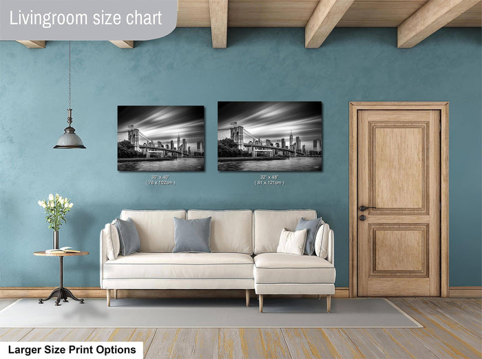 a living room with a white sofa, a wooden door, and two framed black and white photographs of a city skyline hanging on the wall.